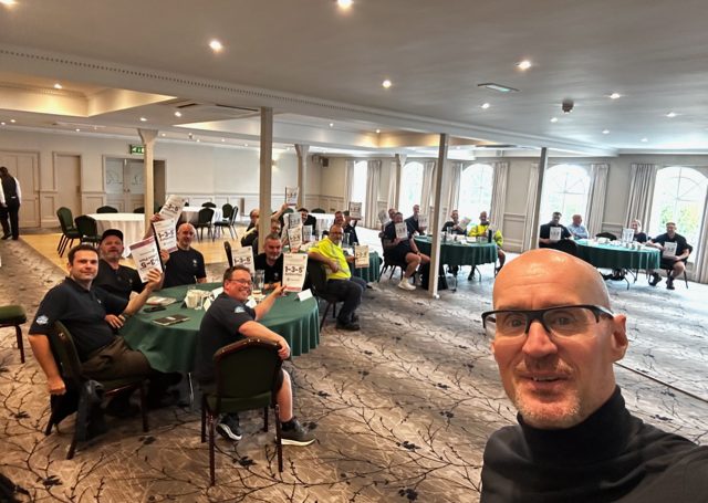 A team holding their 1-3-5 Action Plans at a function room offsite