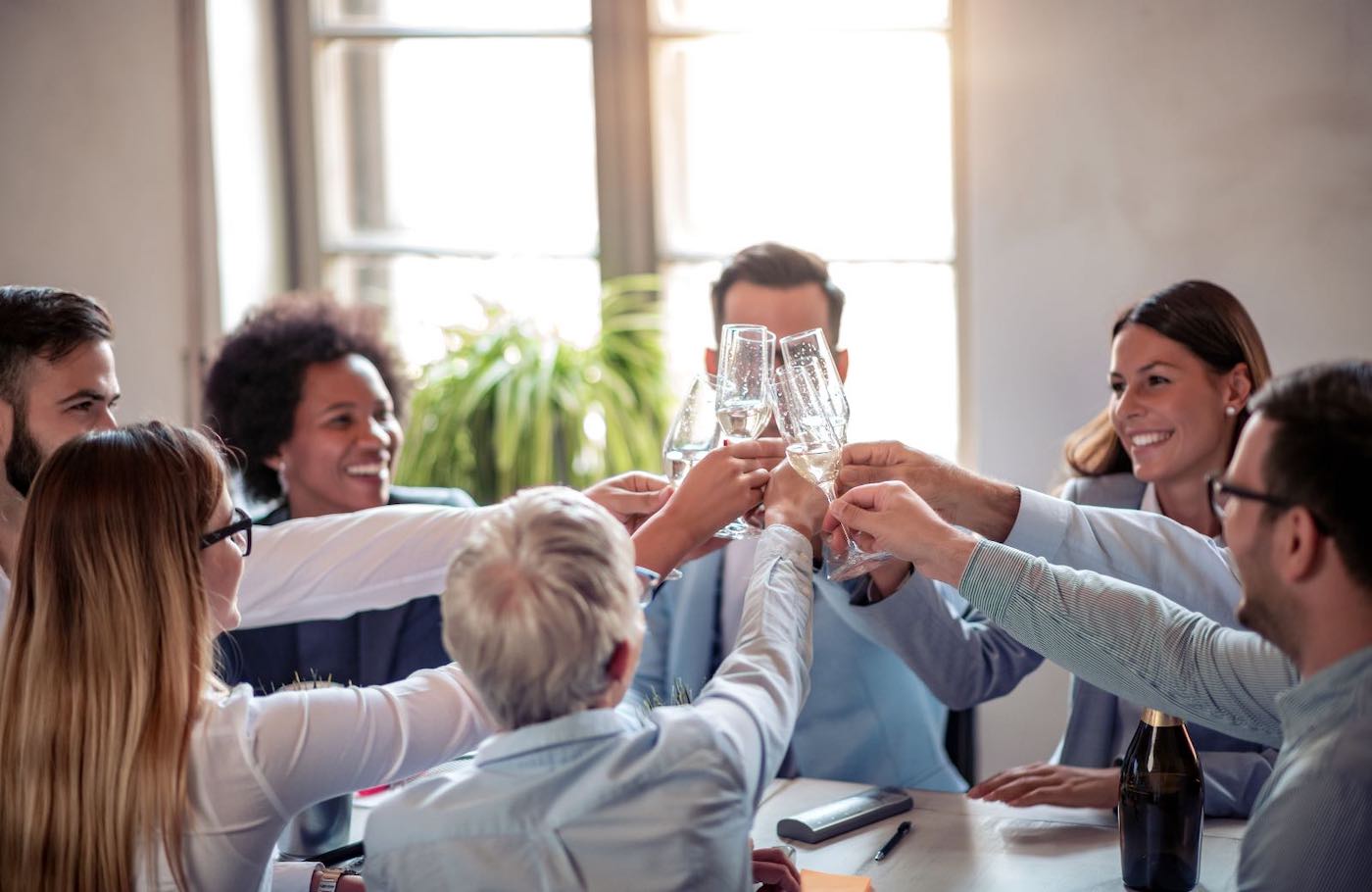 People around a table raising champagne flutes